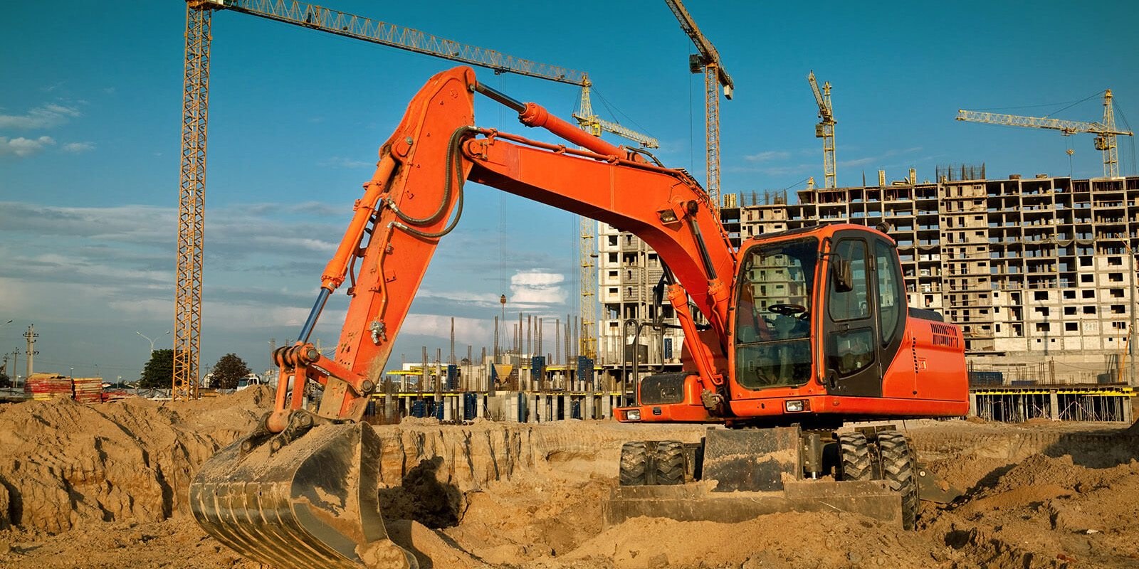 An excavator working a construction site for underground line work