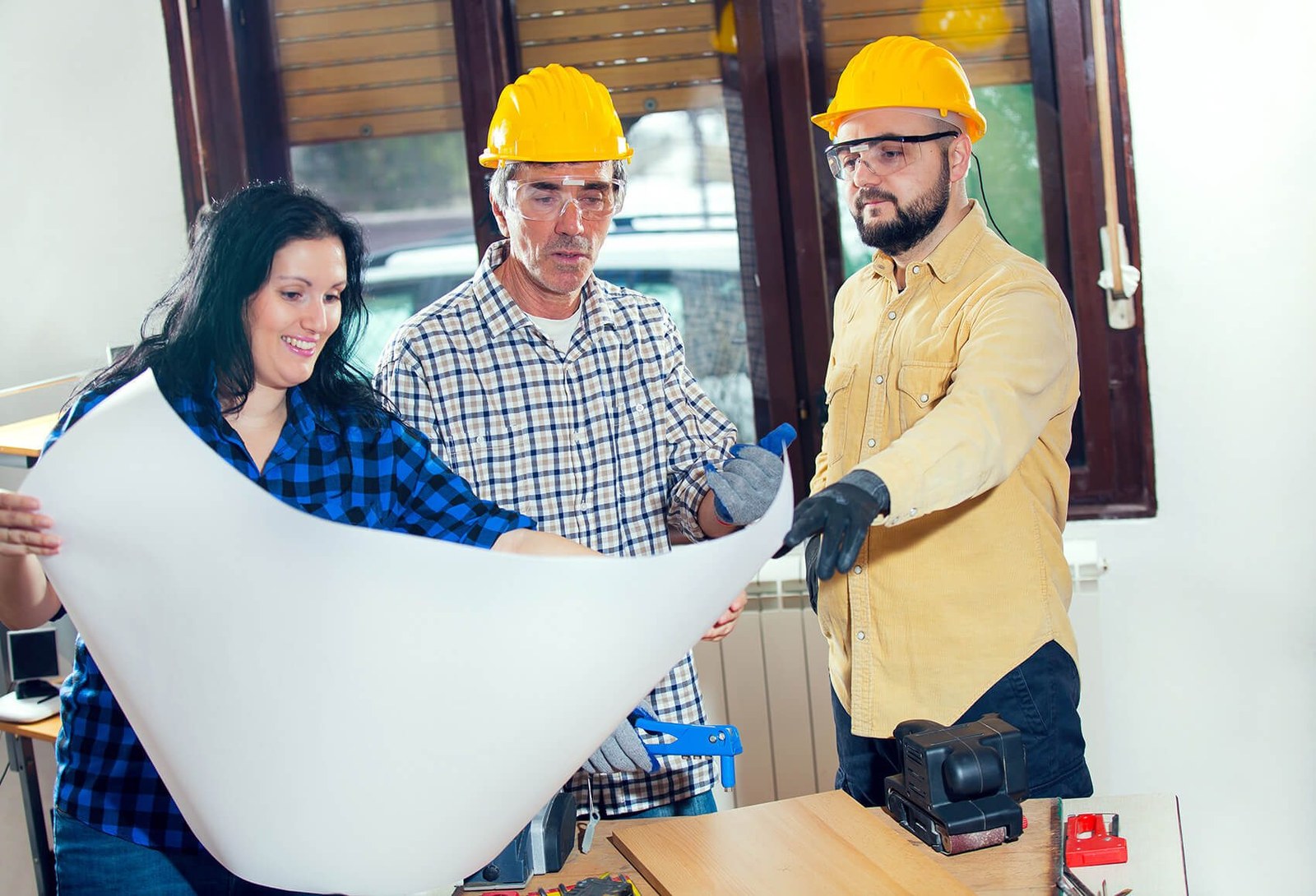 Homeowners and a contractor reviewing remodel plans together
