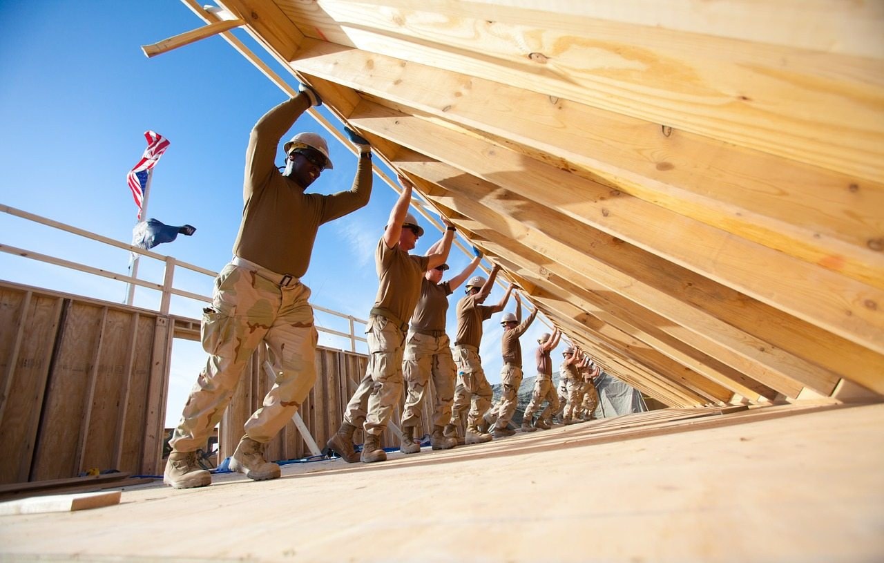 A framing crew raising roof trusses on a new build