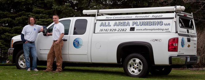 Both owners standing by the white All Area Plumbing truck