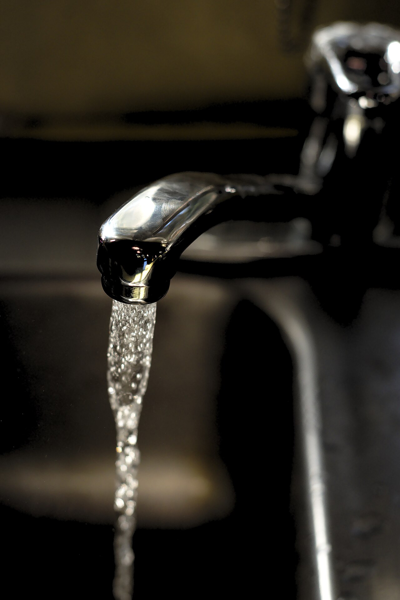 A new chrome kitchen faucet running clean water