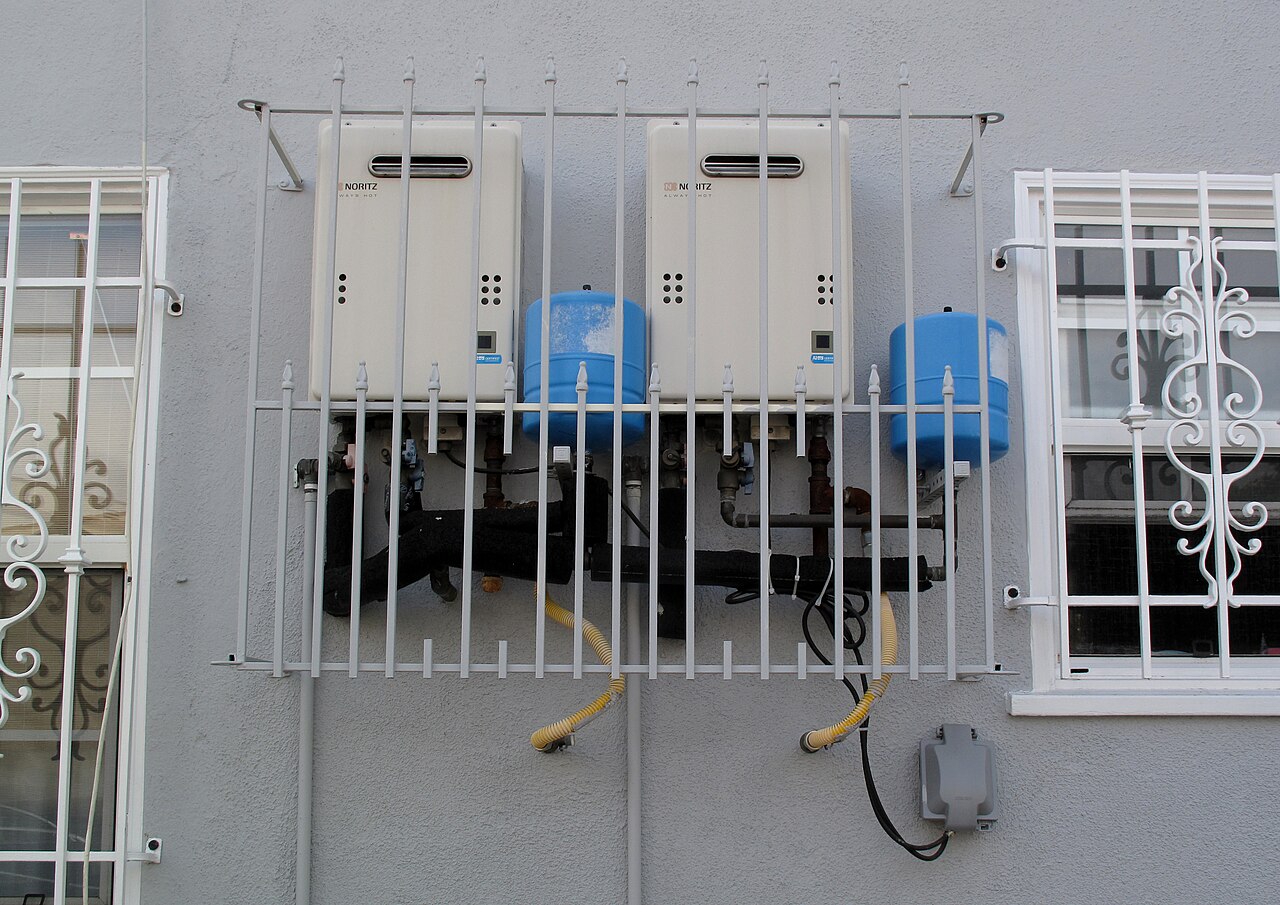 Two tankless water heaters installed on a home's exterior wall