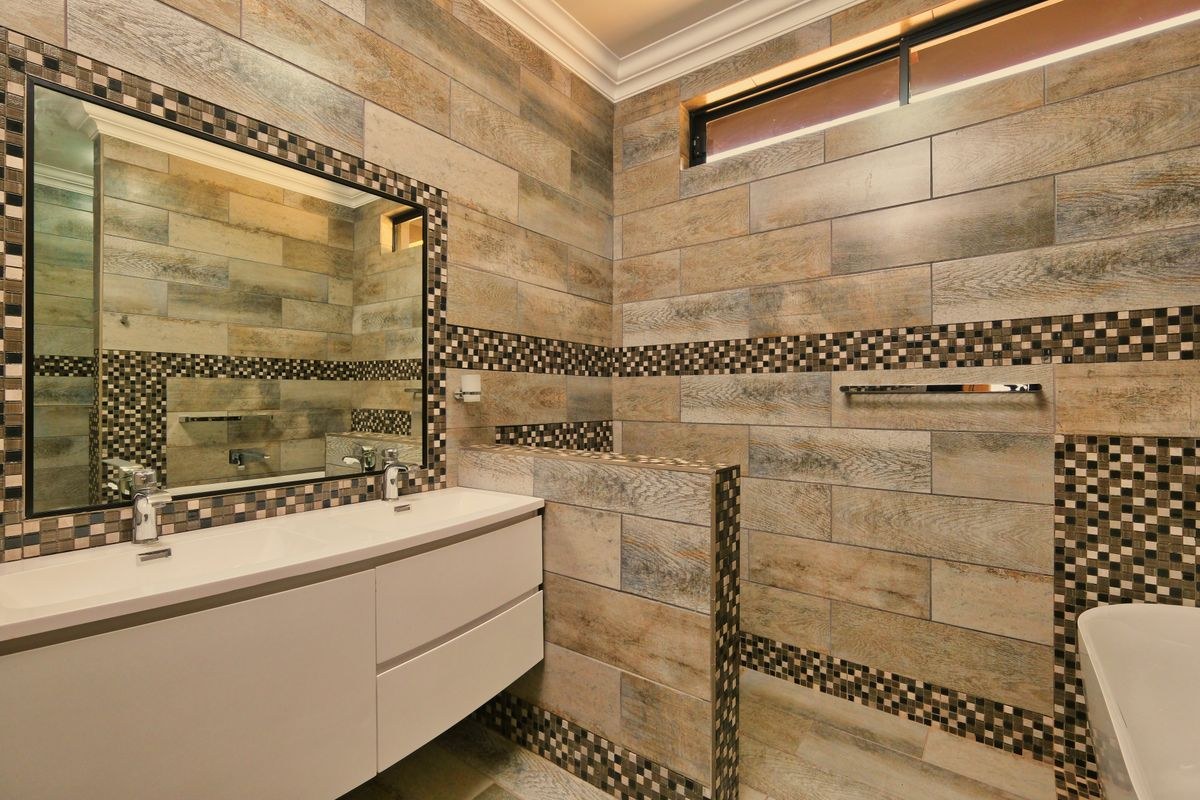 A finished tiled bathroom with a double vanity